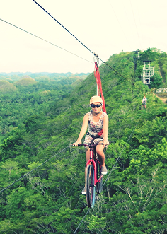woman-riding-bicycle-zip-line-trees